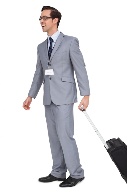Homme d&#39;affaires souriant, marchant avec sa valise