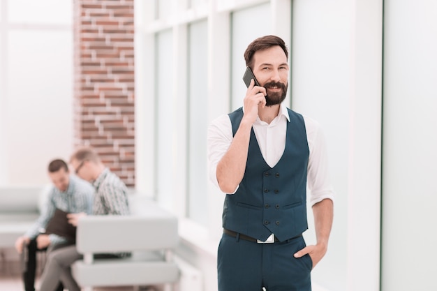 Homme d'affaires souriant parlant sur smartphone dans office.people et technologie