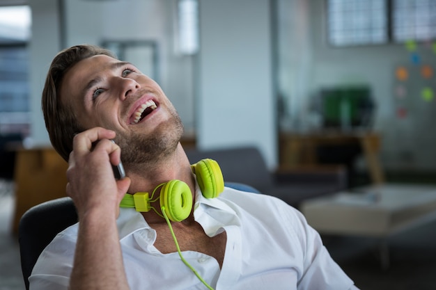 Homme d'affaires souriant, parler au téléphone mobile