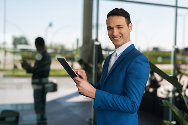 Homme d&#39;affaires souriant avec sa tablette