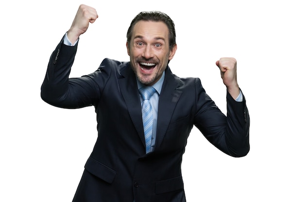 Un homme d'affaires souriant se réjouit de sa victoire. Patron d'âge moyen réussi isolé sur mur blanc.