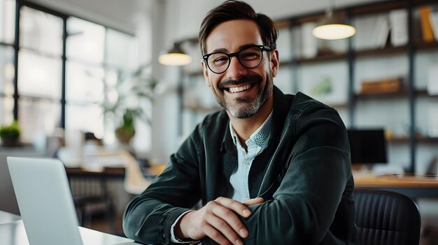 un homme d'affaires souriant travaillant avec son ordinateur portable dans le bureau