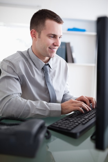 Homme d&#39;affaires souriant travaillant sur son ordinateur