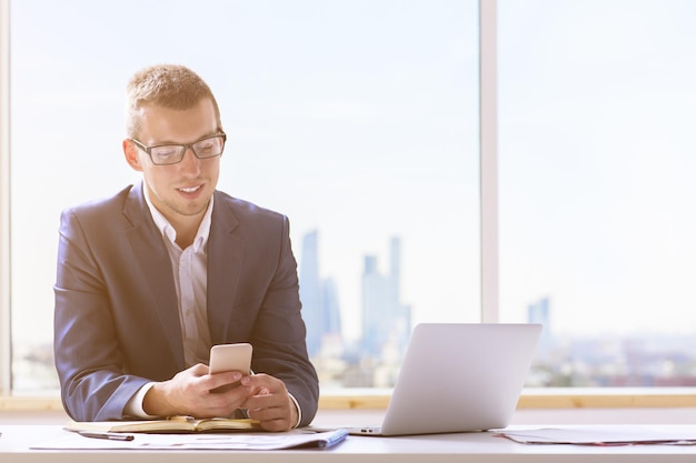 Homme d&#39;affaires souriant en utilisant un smartphone