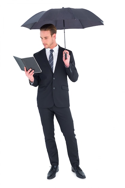 Homme d&#39;affaires sous le livre de lecture de parapluie