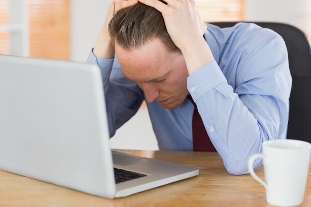 Homme d&#39;affaires stressé avec la tête dans les mains