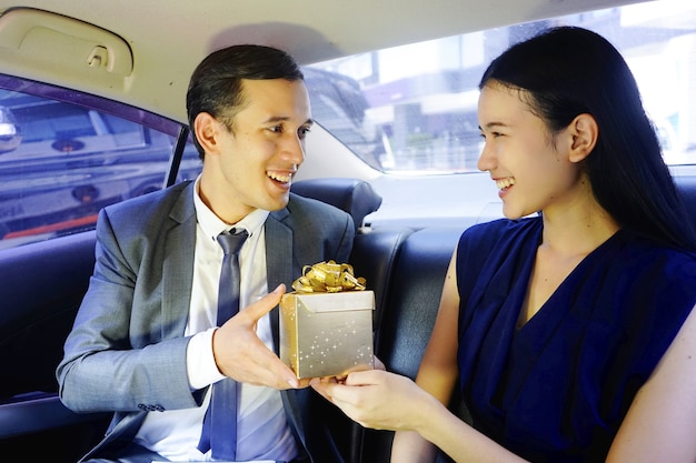 Homme d&#39;affaires surprendre l&#39;amant sur la voiture avec boîte-cadeau. couple heureux famille surprenant chaque