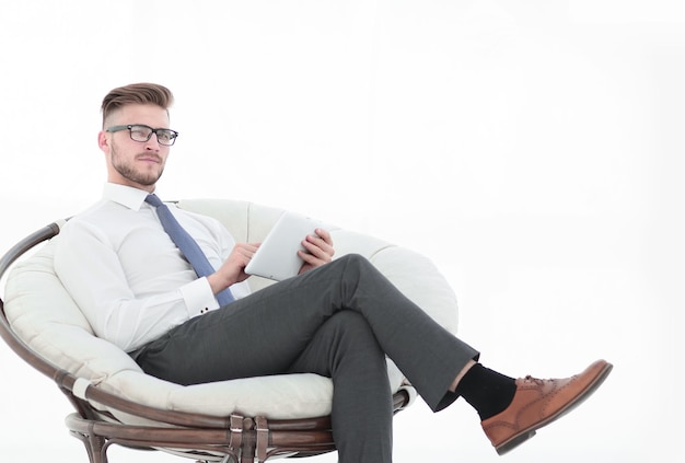 Homme d'affaires avec tablette numérique assis dans le fauteuil isolé