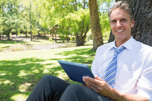 Homme d&#39;affaires avec tablette numérique dans le parc