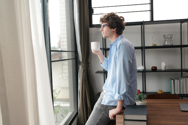 Homme d'affaires avec une tasse de café dans la maison