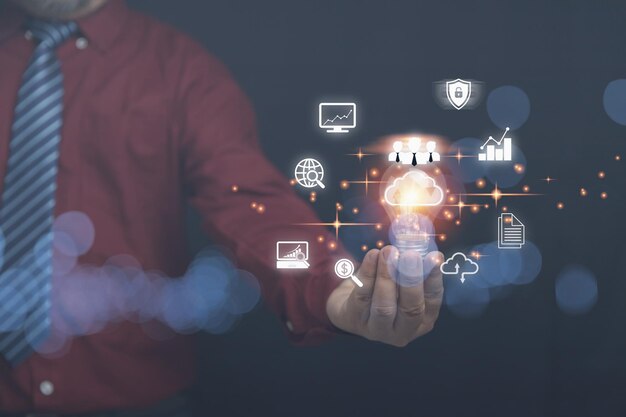 Homme d'affaires tenant une ampoule avec le cloud computing sur les mains avec une icône d'entreprise avec espace de copie Base de données de sécurité et mise en réseau numérique la technologie de l'entreprise au futur concept