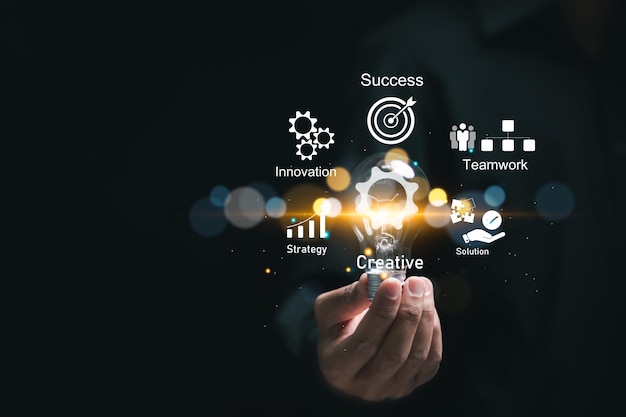 Un homme d'affaires tenant une ampoule avec des icônes virtuelles de stratégie d'entreprise pour une planification de travail efficace conduit au succès de l'entreprise Concept de développement d'entreprise
