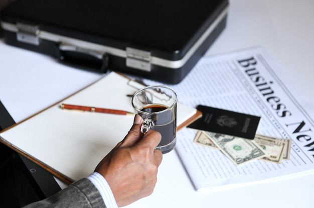 Homme D'affaires Tenant Un Café Avec Le Journal Des Affaires.