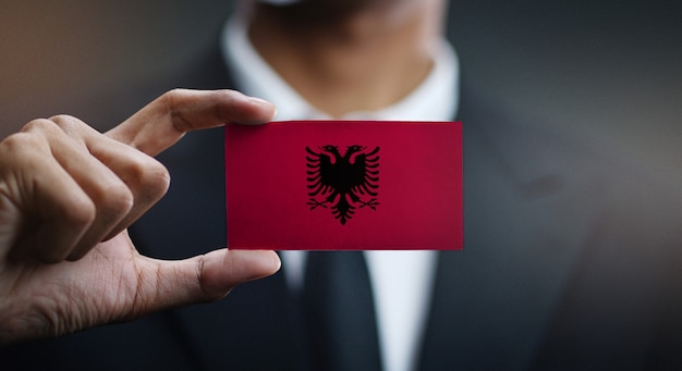 Homme d&#39;affaires tenant une carte du drapeau de l&#39;Albanie