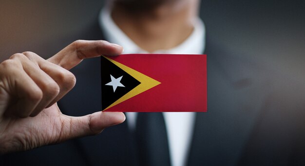 Homme d&#39;affaires tenant une carte du drapeau du Timor oriental