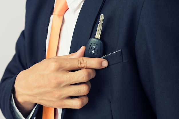 Homme d&#39;affaires en tenant la clé de la voiture, fond isolé