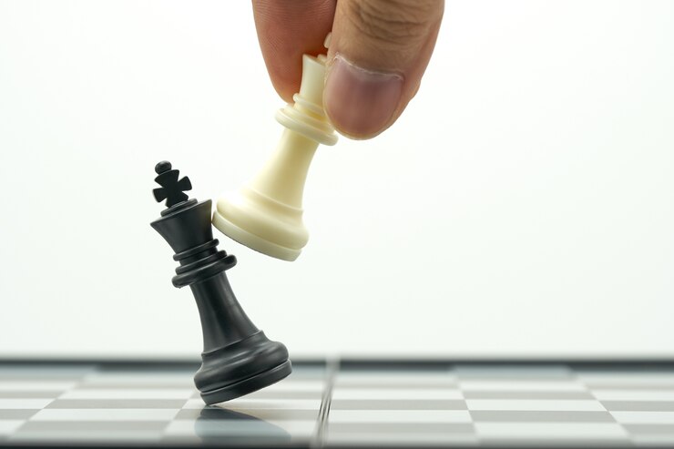Un homme d&#39;affaires tenant un King Chess est placé sur un échiquier.