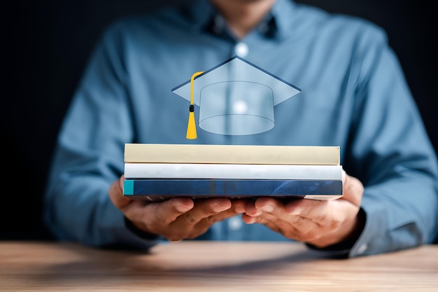 Homme d'affaires tenant un livre avec l'icône du chapeau d'obtention du diplôme économisant de l'argent pour l'éducation future Les frais d'éducation et le coût du diplôme universitaire Les frais de scolarité et le coût total de l'éducation