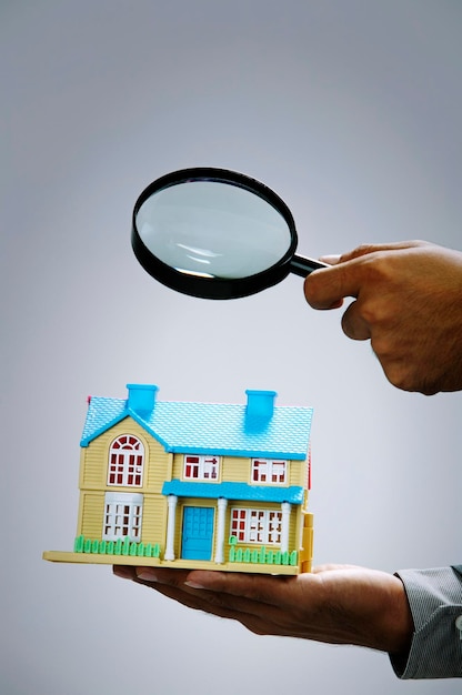 Un homme d'affaires tenant une maison modèle en miniature