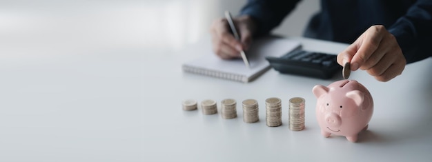 Un homme d'affaires tenant une pièce de monnaie dans une tirelire Placer des pièces de monnaie dans une rangée de bas en haut est comparable à économiser de l'argent pour croître davantage Le concept de croissance de l'épargne et d'épargne en investissant dans des fonds d'actions