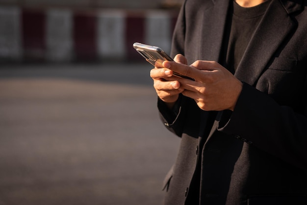 Homme d'affaires tenant un smartphone à l'extérieur