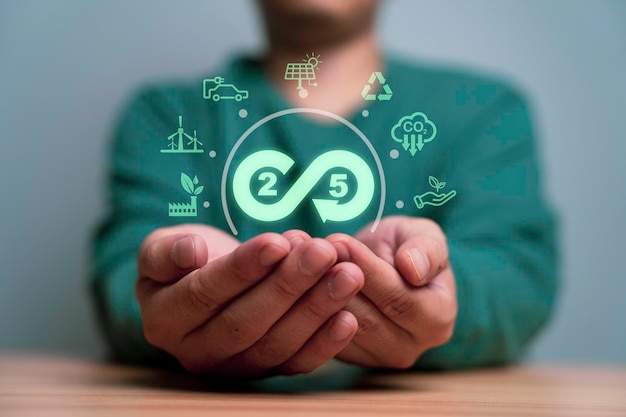 Homme d'affaires tenant le symbole de l'infini 2050 avec l'icône de l'environnement comprend une usine verte, un crédit de réduction de l'empreinte carbone et des énergies alternatives pour l'économie circulaire au concept de développement durable