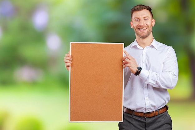 Homme d'affaires tenant un tableau de liège