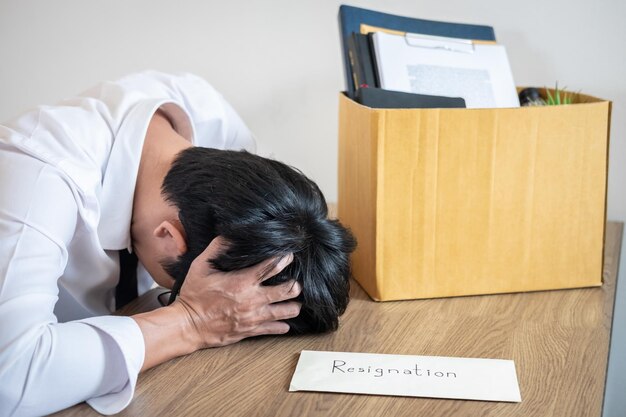 Un homme d'affaires tendu assis à son bureau.