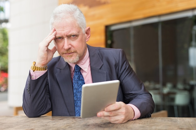 Homme d&#39;affaires tendu avec tablette dans le café de la rue