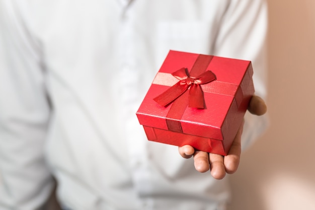 Homme d&#39;affaires tenez la boîte-cadeau rouge dans les mains.