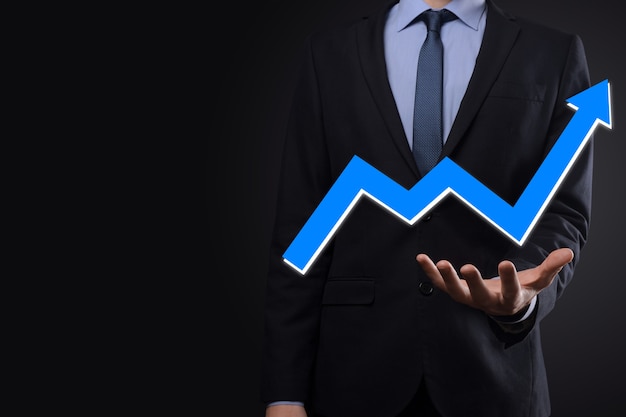 Homme d'affaires tenir dessin sur écran de plus en plus graphique, flèche du symbole de croissance positive. Pointant vers le graphique d'entreprise créative avec des flèches vers le haut. Concept de croissance financière, entreprise.