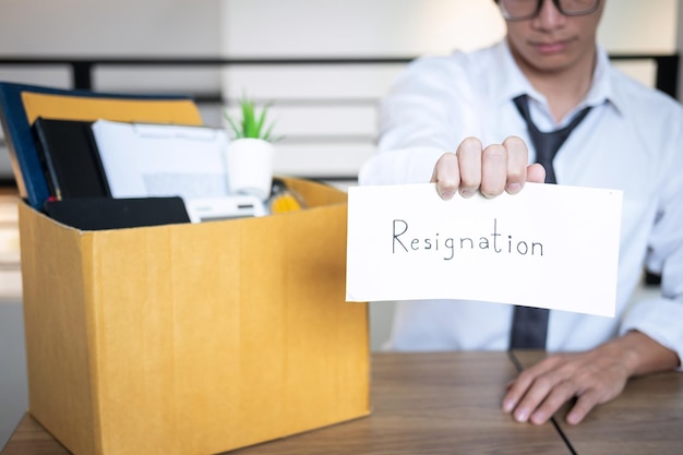 Photo un homme d'affaires tient une lettre de démission sur la table de son bureau.