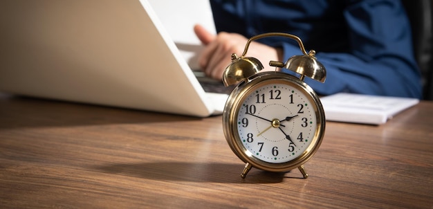 Homme d'affaires travaillant au bureau avec un réveil sur la table