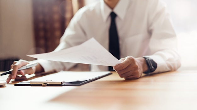 Homme d&#39;affaires travaillant au bureau avec signer un document et un ordinateur portable.