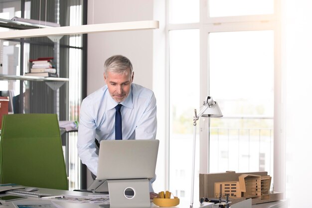 Homme d'affaires travaillant dans son bureau, utilisant aptop