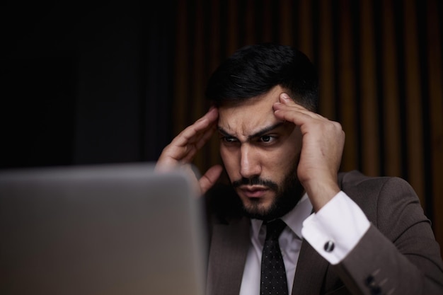 Homme d'affaires travaillant sur un ordinateur portable dans un hall de bureau moderne