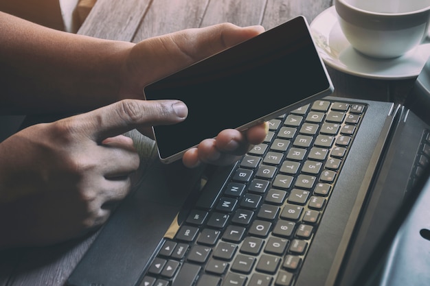 Photo homme d'affaires travaillant avec un ordinateur portable et utilisant le téléphone garder une trace des taxes à la clientèle