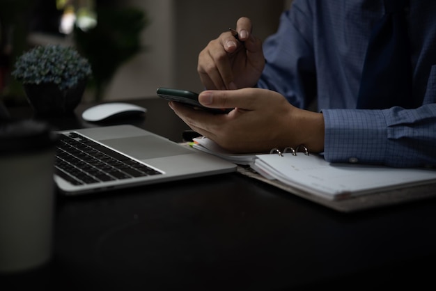 Homme d'affaires travaillant sur un ordinateur portable et utilisant un téléphone portable sur le concept de technologie numérique de bureau