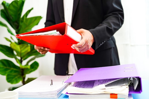 Homme d'affaires travaillant et préparant des données de rapport de paperasse pour analyser les informations dans le classeur de fichiers au bureau