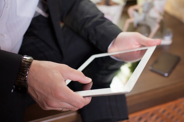 Homme d'affaires travaillant sur une tablette dans un café