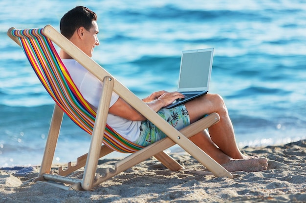 homme d'affaires travaillant avec une tablette sur la plage