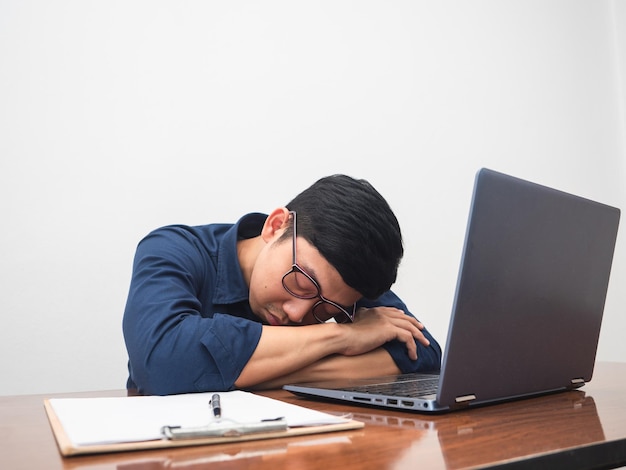 L'homme d'affaires travaille dur et se sent essayé à la table de travail