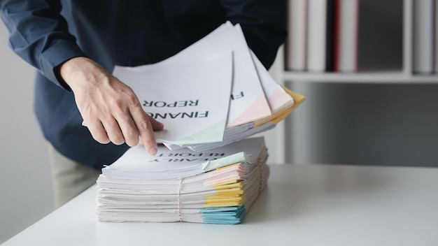 Homme d'affaires triant des piles de documents de réunion de département gestion de documents au siège social concept de gestion et de stockage de documents de bureau