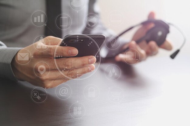 Homme D'affaires Utilisant Un Casque Voip Avec Un Téléphone Mobile Et Un Centre D'appels De Communication Concept