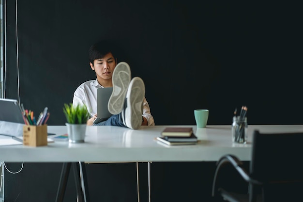 Photo homme d'affaires utilisant un ordinateur portable alors qu'il est assis au bureau