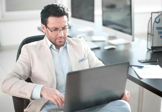 Homme d'affaires utilisant un ordinateur portable assis à son bureau
