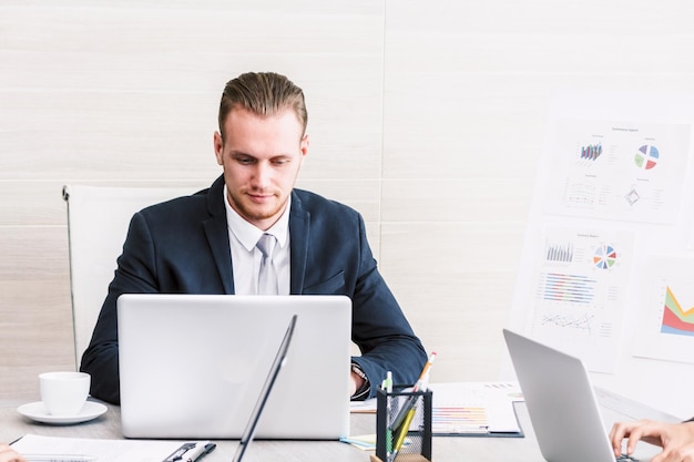 Homme d'affaires utilisant un ordinateur portable pendant son travail au bureau