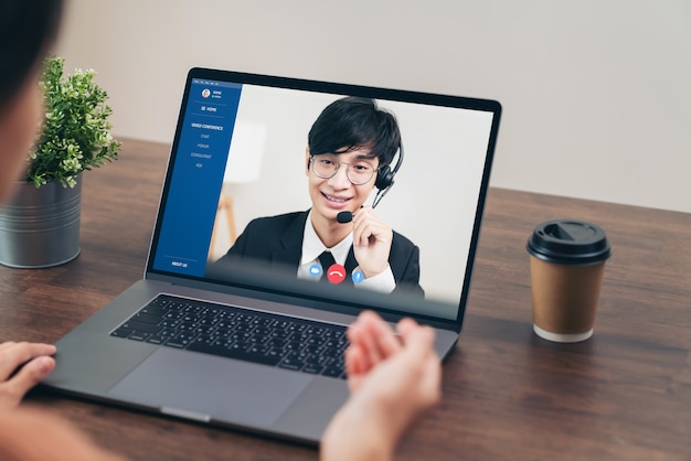 Homme d'affaires utilisant un ordinateur portable sur une table avec une réunion par appel vidéo avec l'opérateur téléphonique du support client.