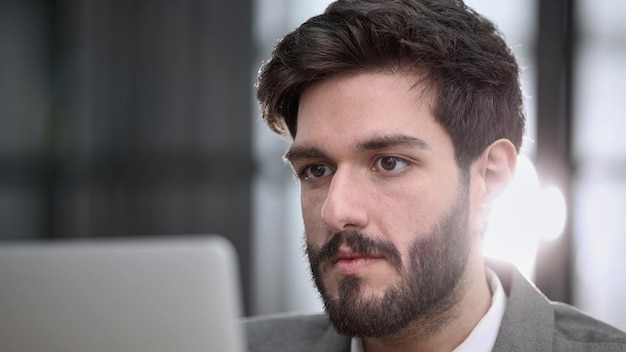 Homme d'affaires utilisant un ordinateur portable tout en travaillant tard dans son bureau