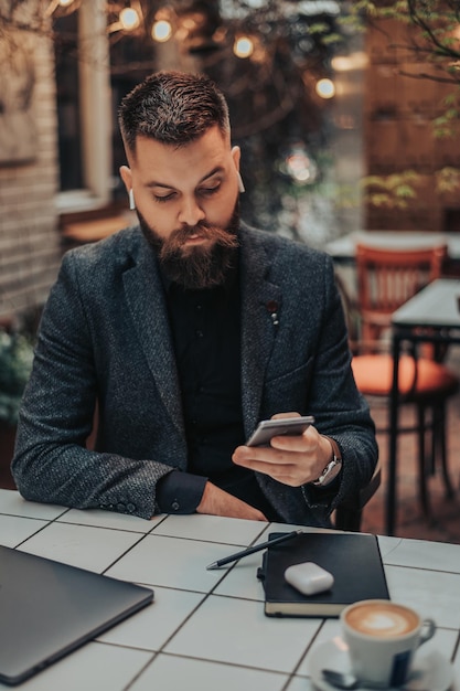 Homme d'affaires utilisant un smartphone dans un café